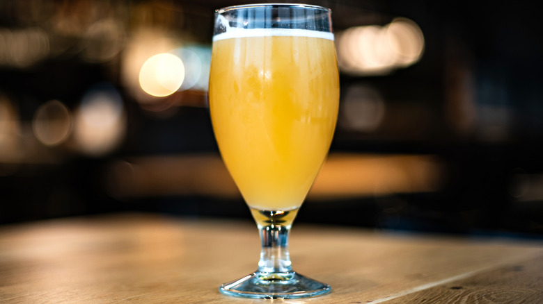 Tulip glass of beer on bar.