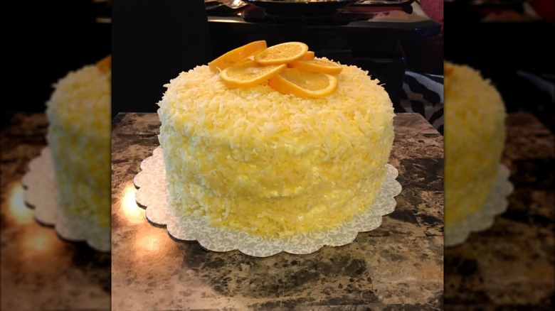 Moss Rose Cake covered with grated coconut and orange slices