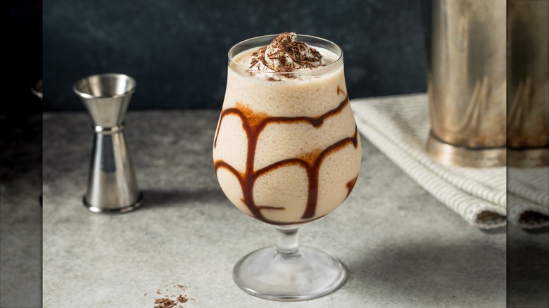 Mudslide cocktail in tulip glass with whipped cream and chocolate shavings