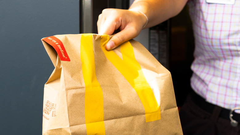 Man holding McDonald's paper bag