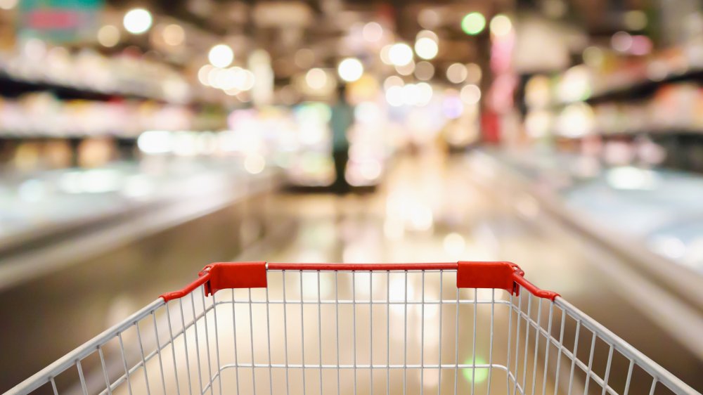 grocery cart with blurred supermarket interior in the background