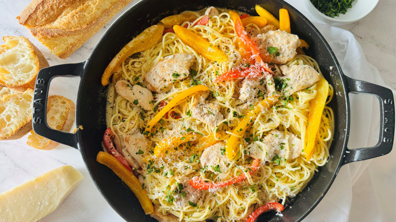 pasta with bell peppers, cheese, and chicken in a black pot