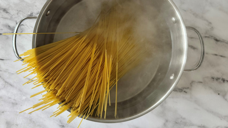 raw noodles standing in a pot of water