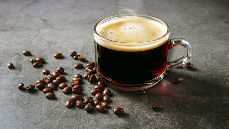 cup of coffee on stone counter with beans