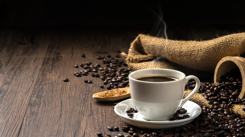Mug of coffee next to beans