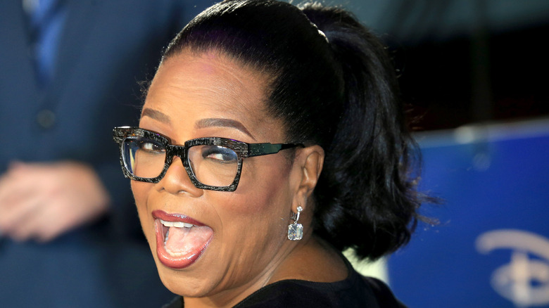 Oprah smiling with her head tilted to the side 