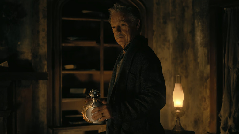 Roderick Usher holding cognac bottle
