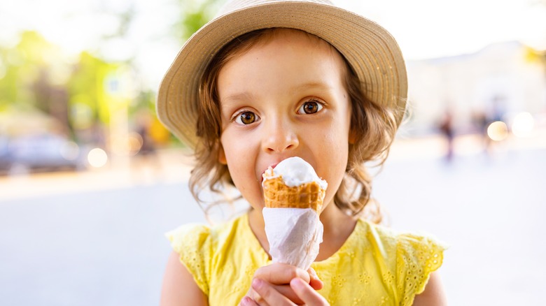   Maža mergaitė valgo ledų kūgį