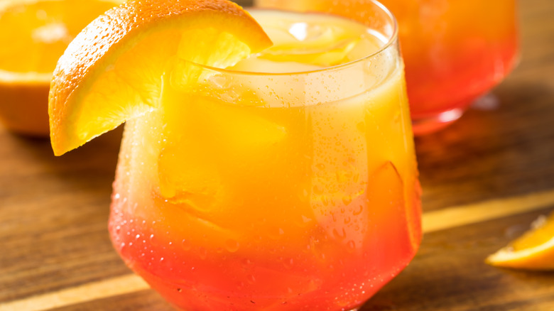 Tequila sunrise cocktail in a glass with orange wedge