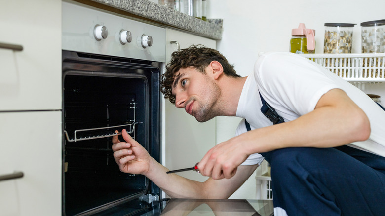 Person fixing a faulty kitchen oven