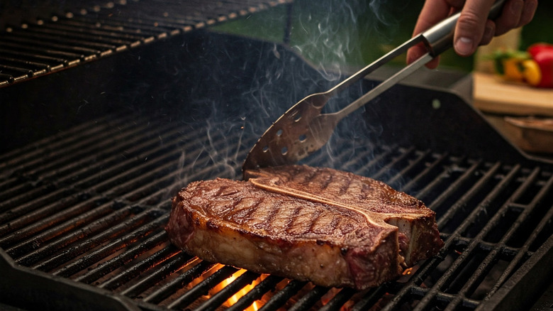 Steak on a grill with tongs