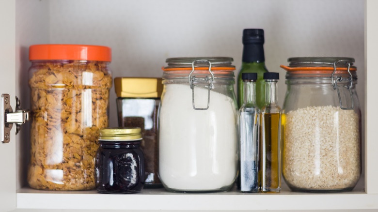 A well-stocked pantry shelf with clear jars