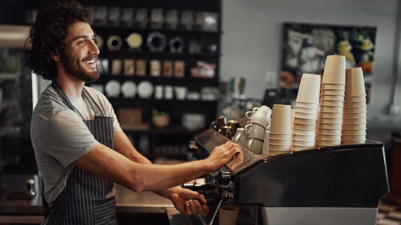 Cheerful barista working behind coffee bar