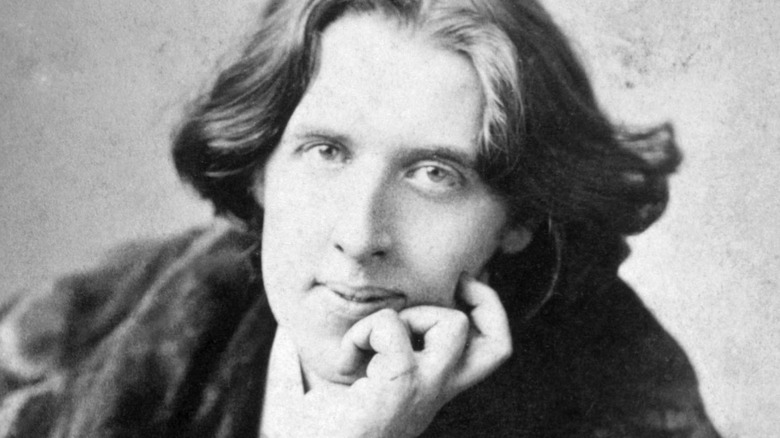 Oscar Wilde smiling in a fur coat 