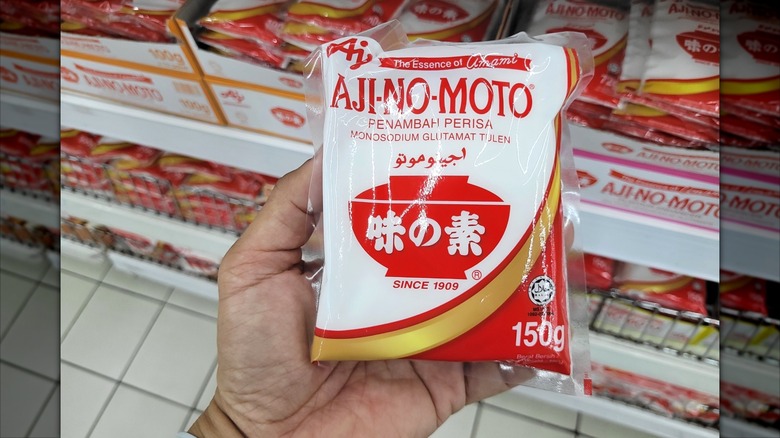 Person holding bag of MSG seasoning in grocery store