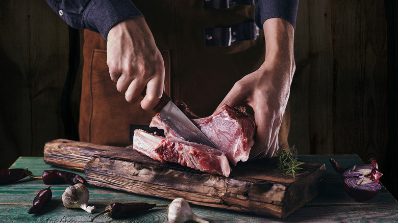 Chef cutting raw meat