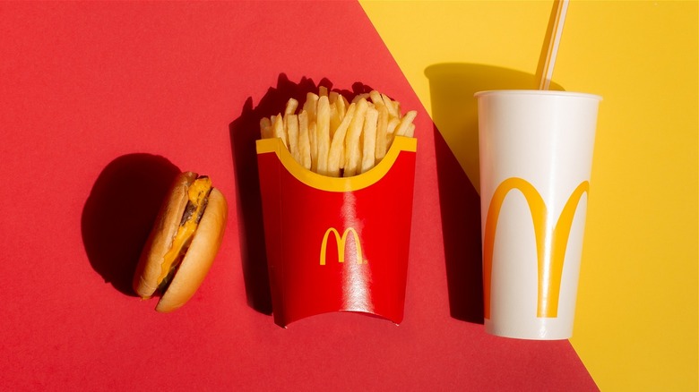 McDonald's burger, fries, and drink on red-and-yellow background