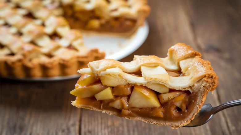 A slice of apple pie on a metal fork