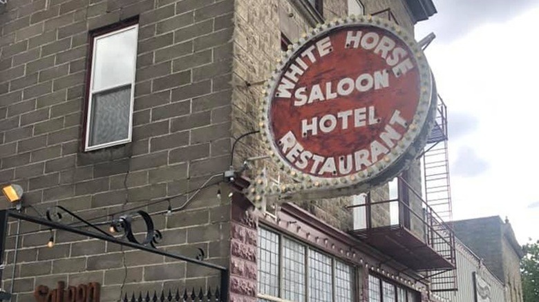 Sign on the building outside of White Horse Saloon