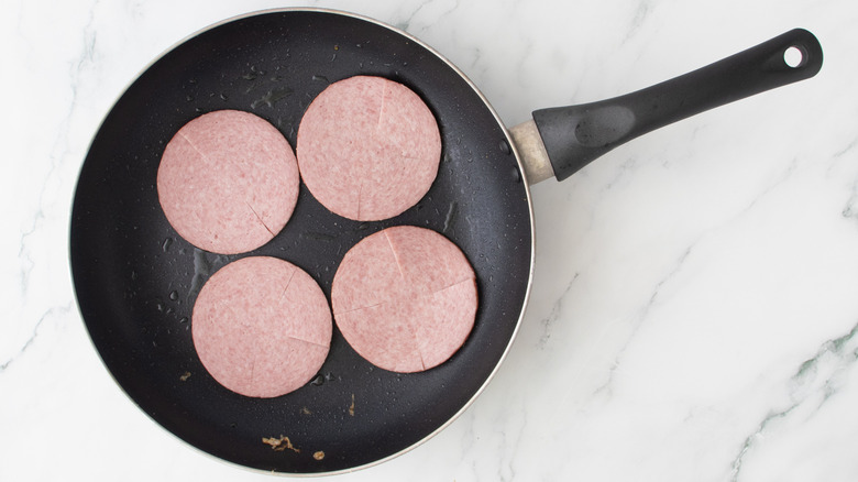 pork roll cooking in skillet