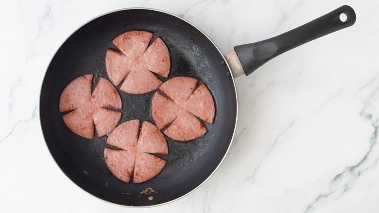 browned pork roll slices in skillet