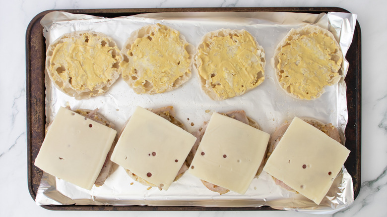english muffin halves topped with pork and cheese