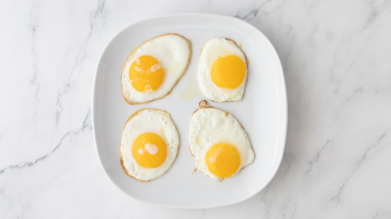 four fried eggs on plate