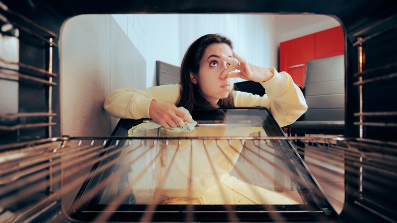 Woman cleaning an oven