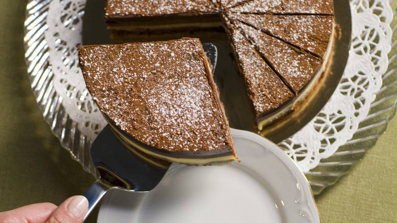 A slice of chocolate cake being lifted with a cake holder