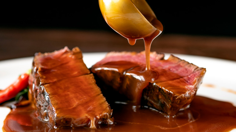 Steak sauce poured from ladle