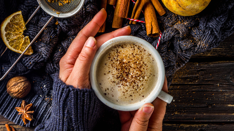 Hands holding chai with spices