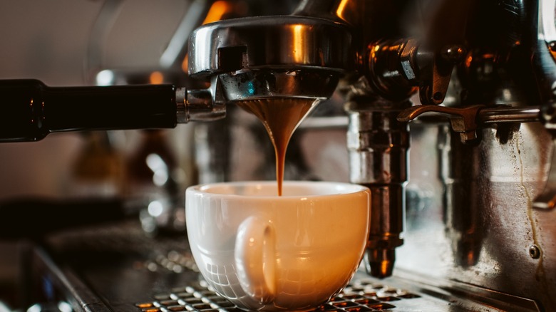Espresso dripping into mug