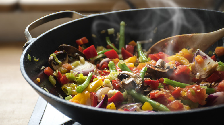 Steam frying vegetables in pan