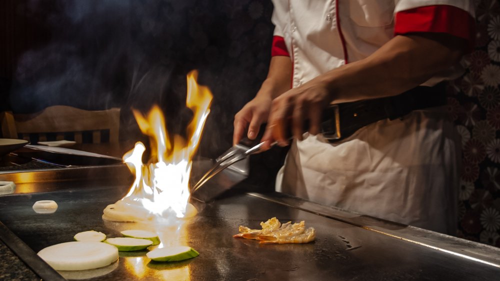 Chef cooks on teppanyaki grill