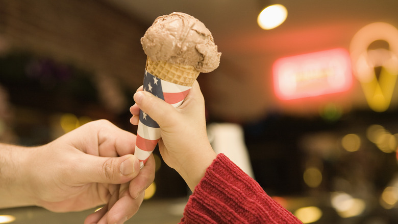 Two hands sharing an ice cream cone