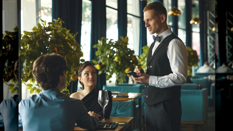 A server talking to a couple out to dinner at a restaurant