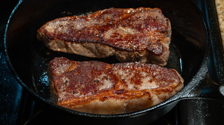 Seared steaks close together in cast-iron skillet