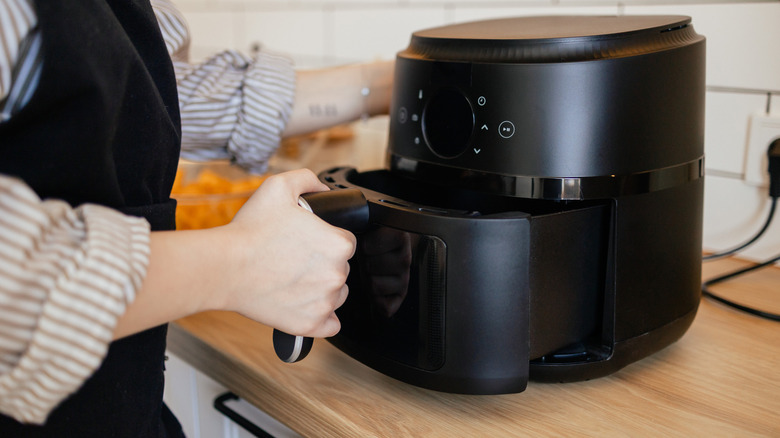 Person removing air fryer basket