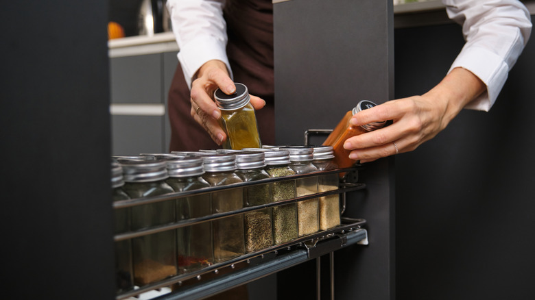 Hands grabbing spices from drawer