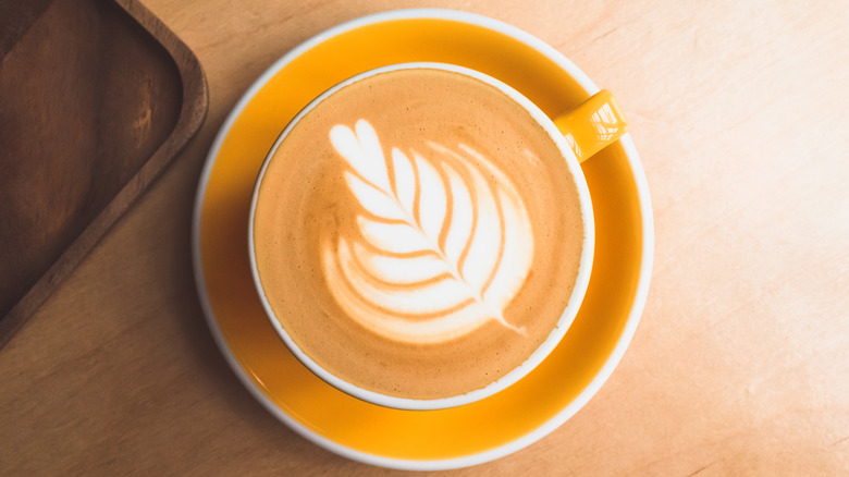 Tulip latte art in yellow cup