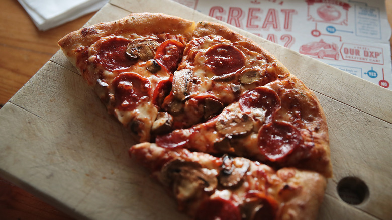 Four slices of Domino's pizza with mushrooms