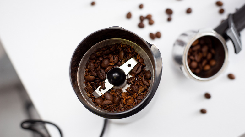 Top view of bladed coffee grinder with beans