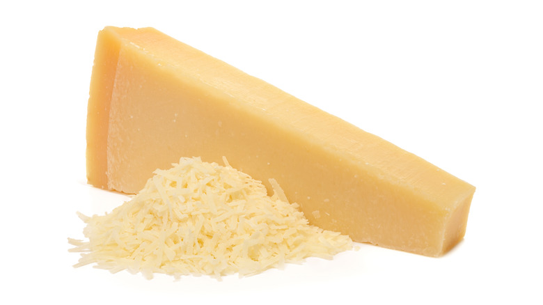 Grated parmesan beside a solid brick