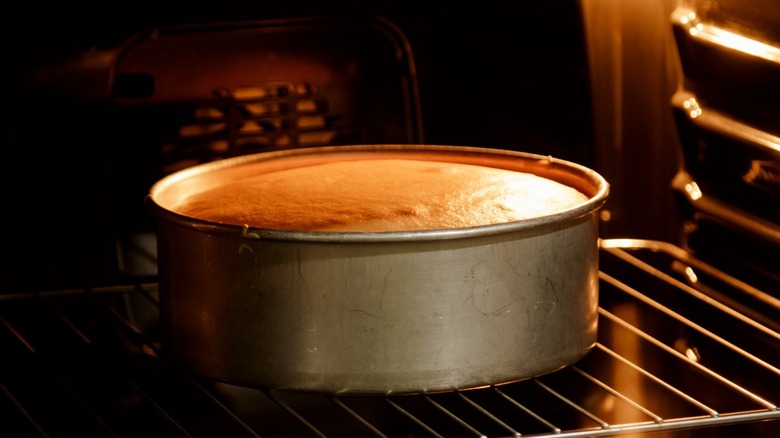 vanilla cake baking in the oven in a round, deep cake pan