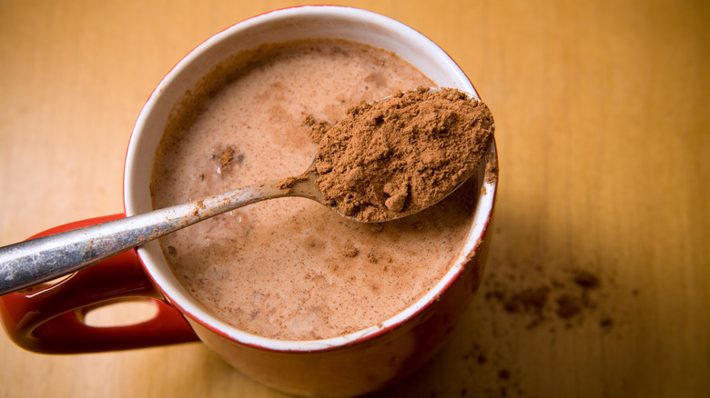 Spoon of cocoa on hot chocolate mug