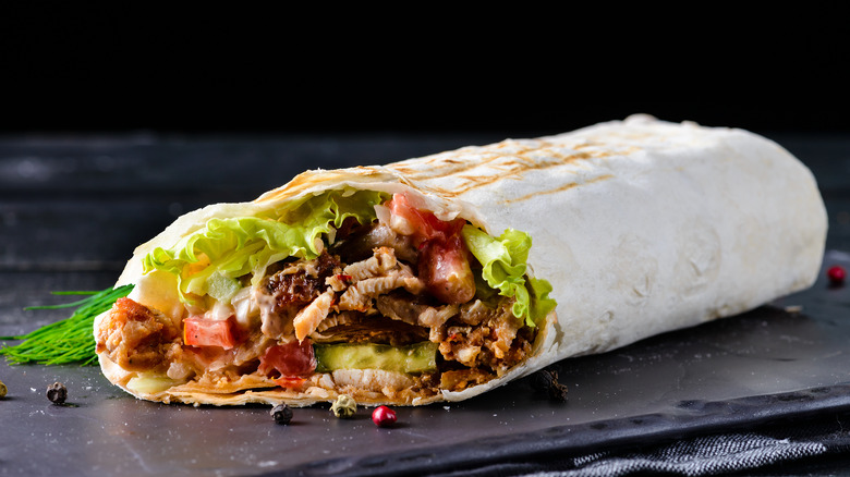 A burrito on black tray