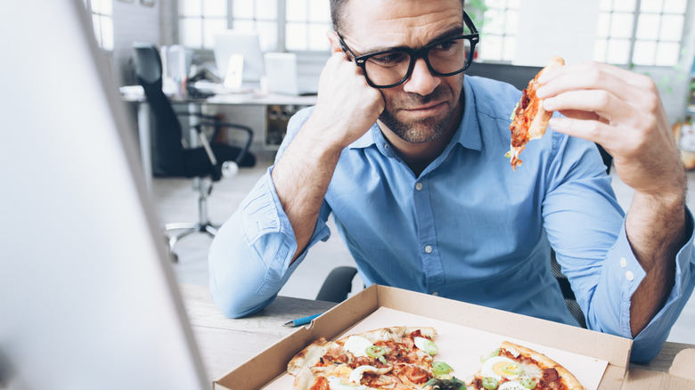man disinterested in his pizza