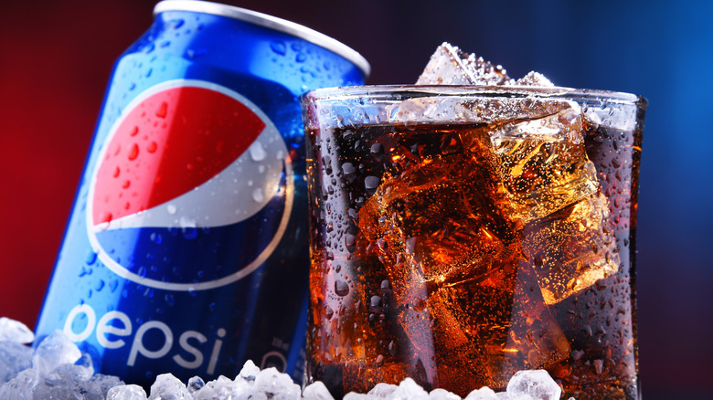 Pepsi can and glass with ice