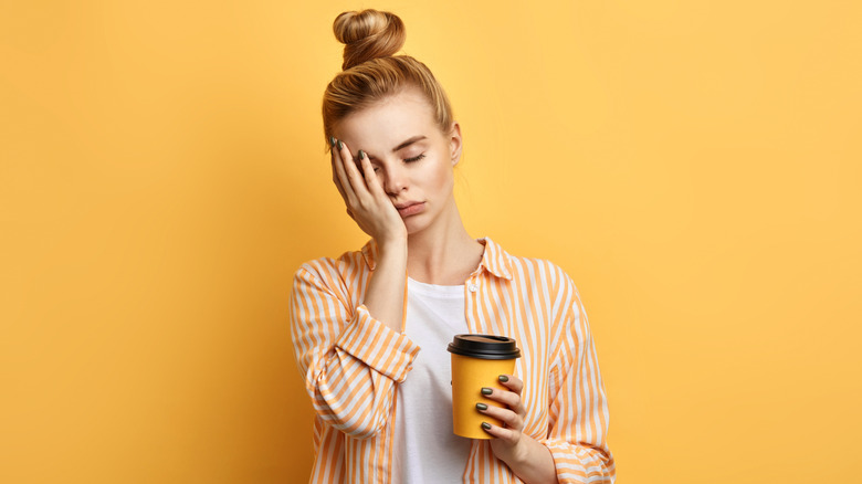 sleepy woman holding coffee
