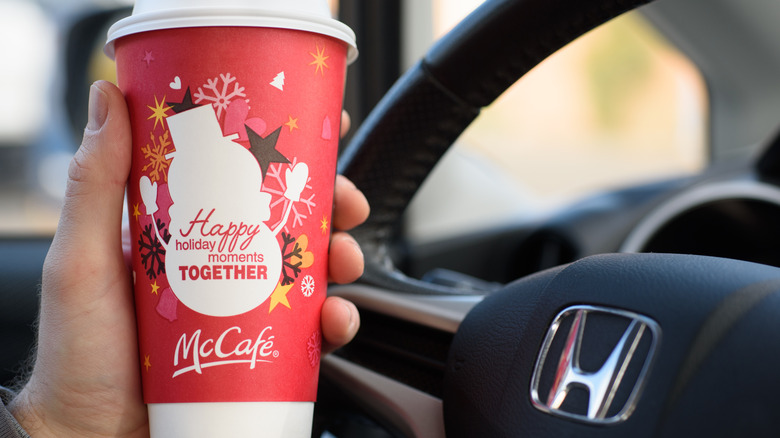 Hand holding a red McCafe cup